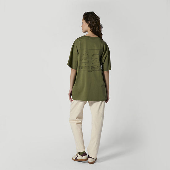 Person im olivgrünen Oversized-T-Shirt mit großem Helm-Blueprint-Aufdruck